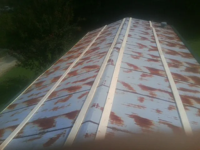 Rusted metal roof panels with new wood purlins before replacement — Storm Damage Roof Repair in Boxholm by Roofing Brothers