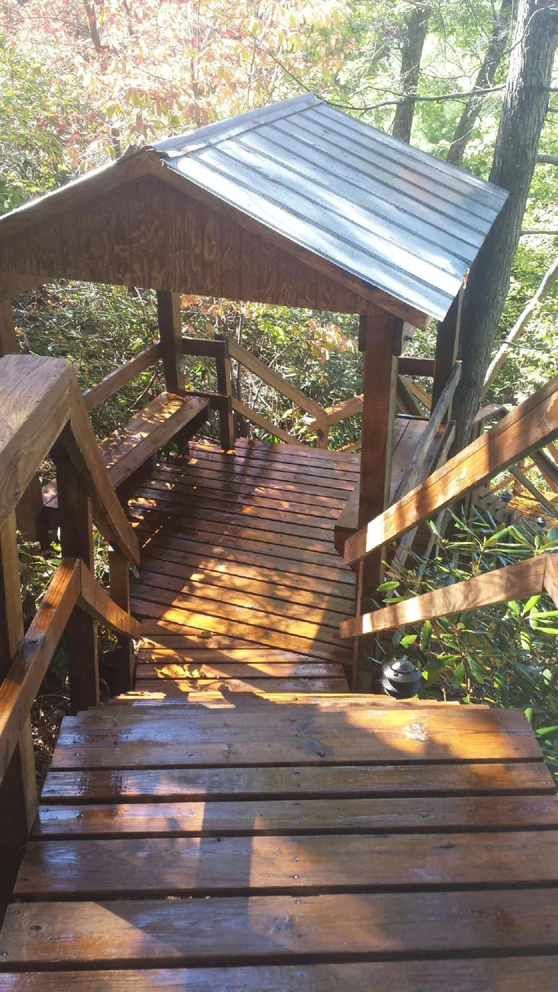 Freshly stained wood walkway and covered shelter with a metal roof in Boxholm
